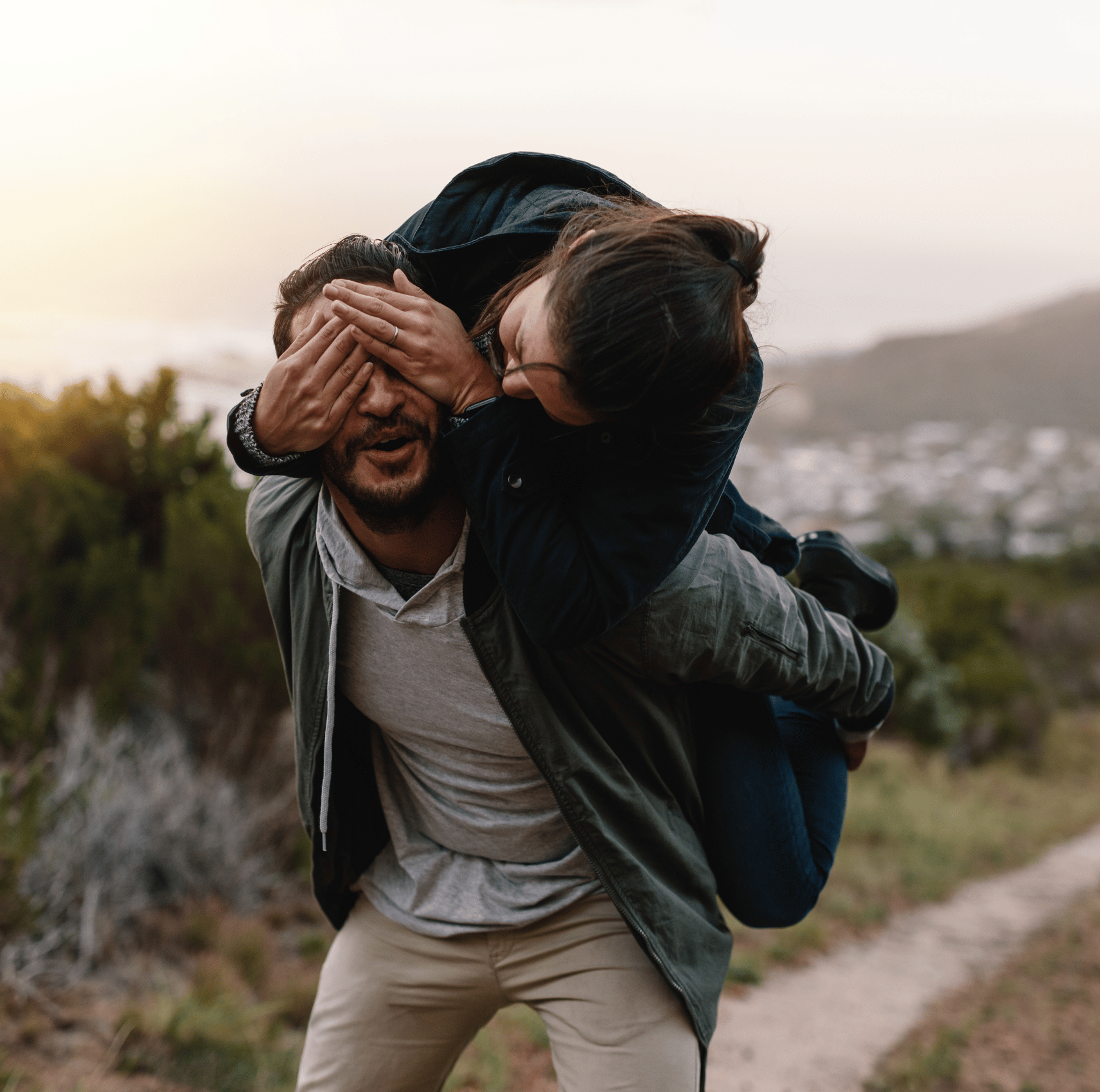 Couple piggy backing by the sunset