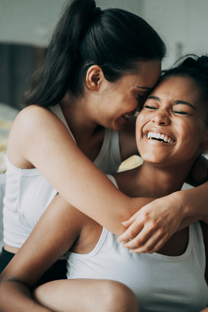 Same sex couple laughing - women holding her partner